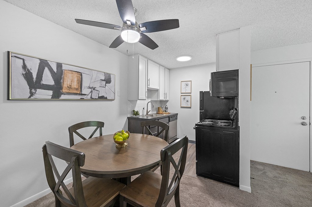 Dining area with a table and chairs and a kitchen in the background  at Timber Glen Apartments, Ohio
