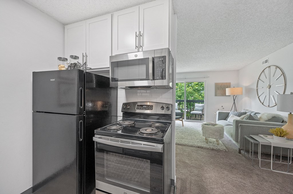 Kitchen and living room with a large clock on the wall  at Timber Glen Apartments, Batavia, OH