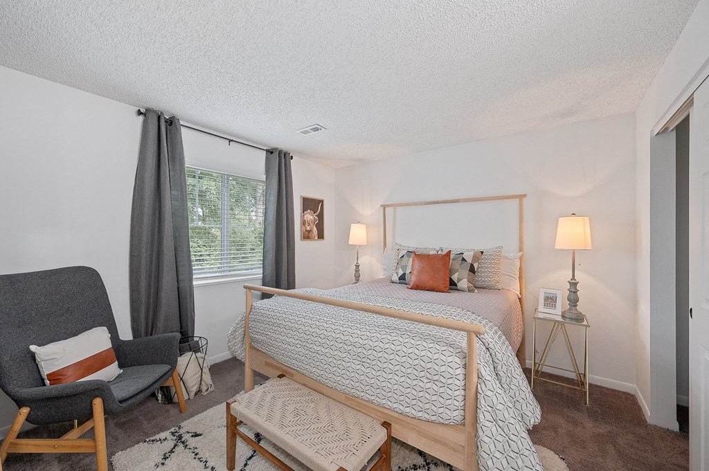 Bedroom with a bed and a chair  at Timber Glen Apartments, Batavia
