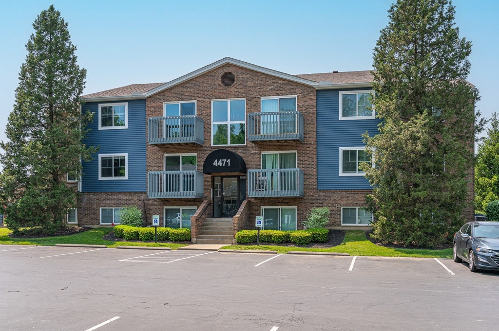 an apartment building with a parking lot in front of it