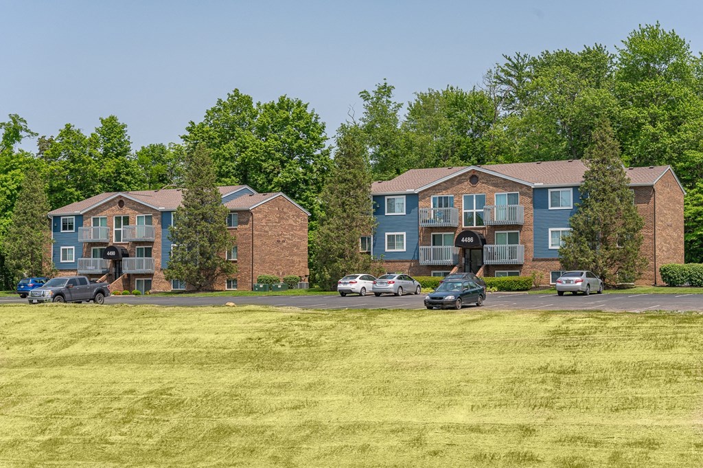 an aerial view of an apartment building with a grass field
