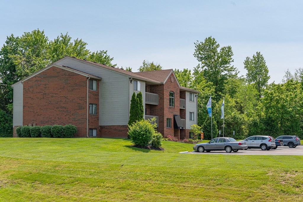 a large brick apartment building with cars parked outside