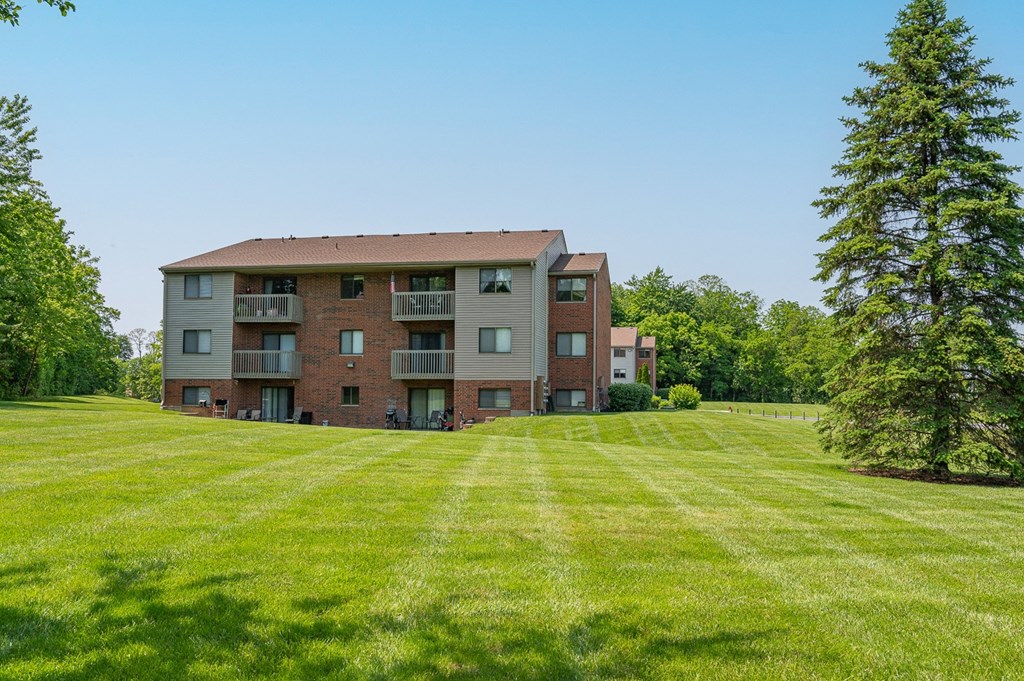 a large apartment building on a green lawn