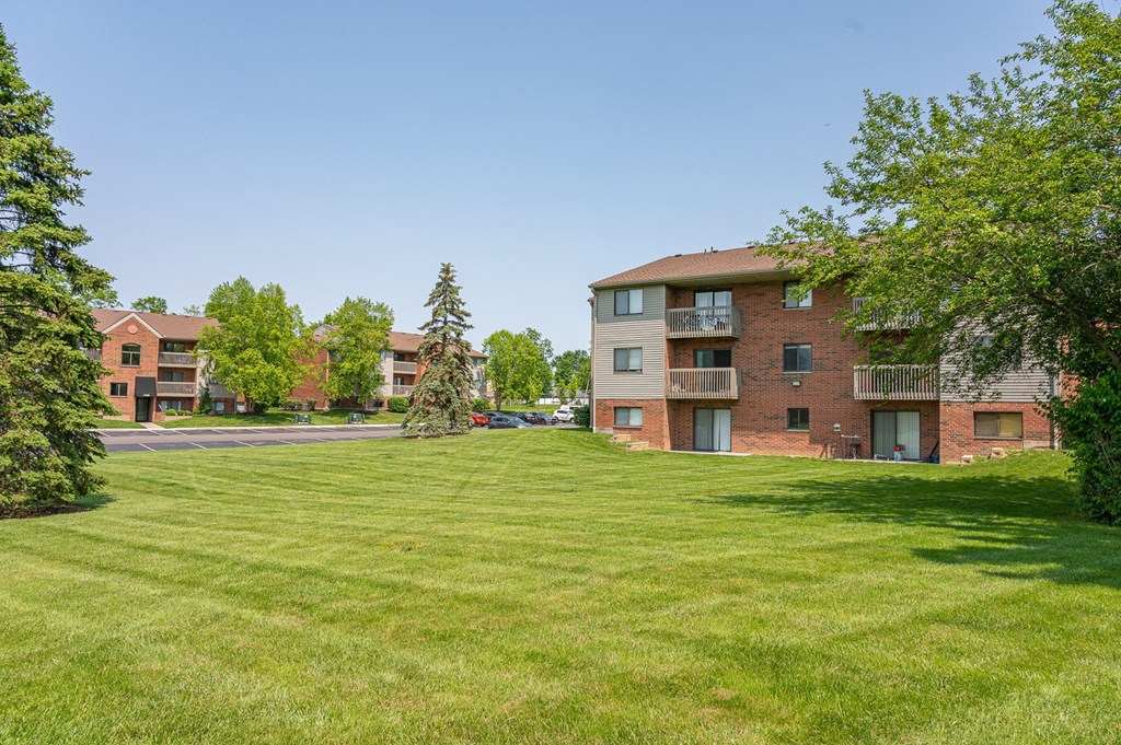 a green lawn in front of an apartment building