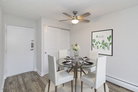 a dining room with a table and chairs and a ceiling fan