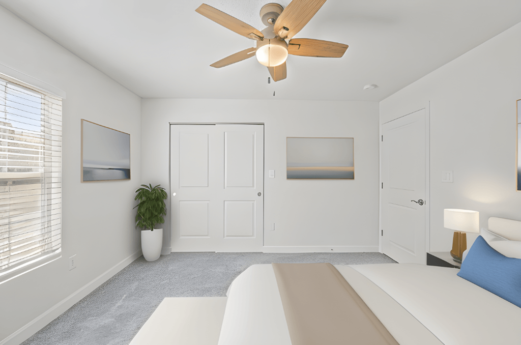 a white bedroom with a white bed and a ceiling fan