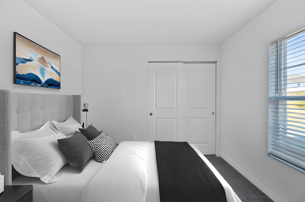 a bedroom with a large white bed and black and white pillows