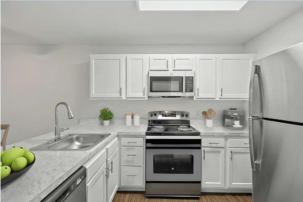 an apartment kitchen with stainless steel appliances and white cabinets