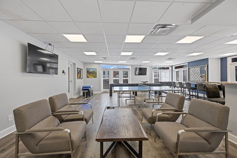 a common room with chairs and tables and a pool table