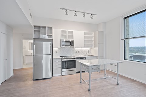 A modern kitchen with stainless steel appliances and a large island.