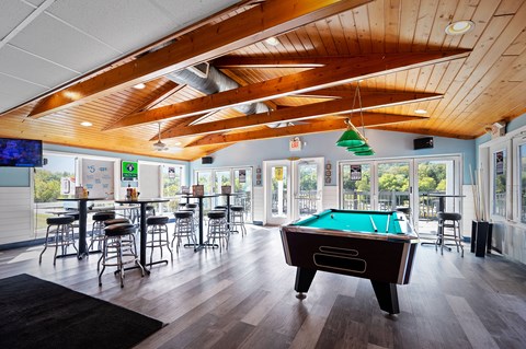 a game room with a pool table and tables