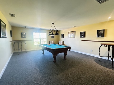 A pool table is in the middle of the room.