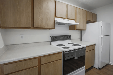 Kitchen with wooden cabinets and a white fridge at Waterfront Pointe, Indianapolis, IN