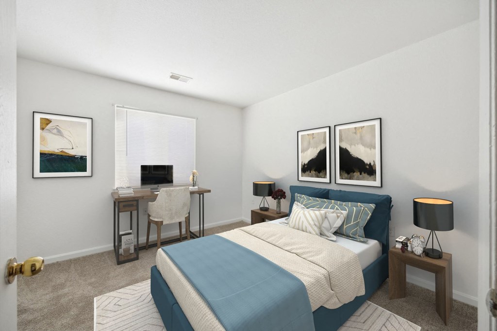 A bedroom with a bed, desk, and chair.