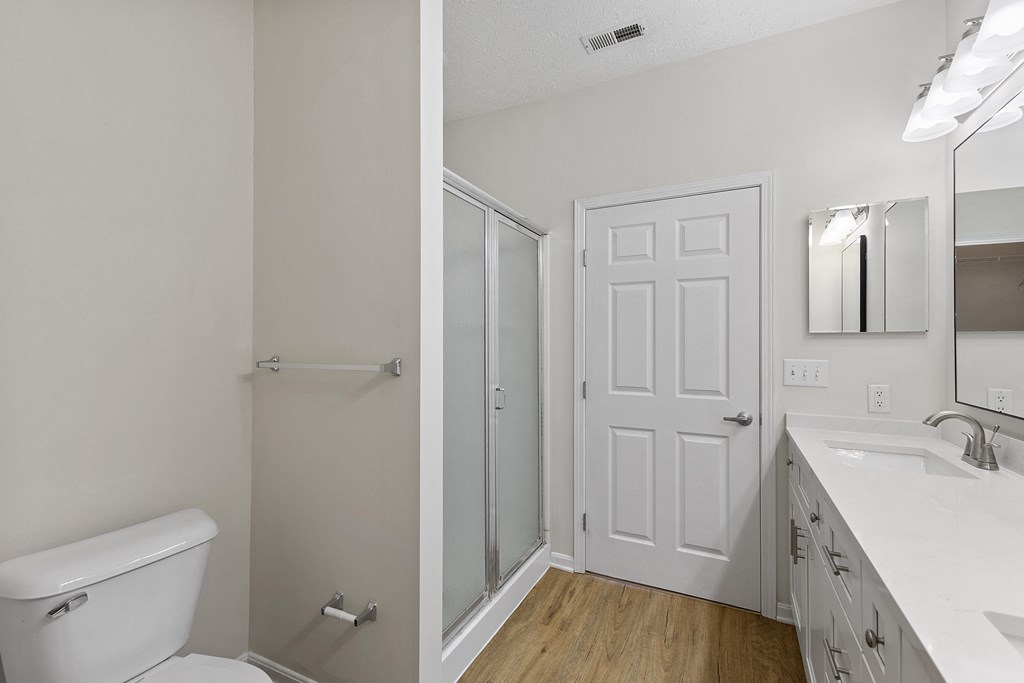 an empty bathroom with a toilet and a shower and a sink
