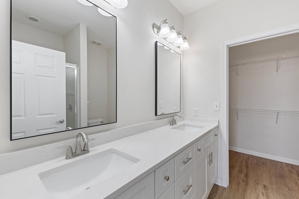 a white bathroom with two sinks and a large mirror