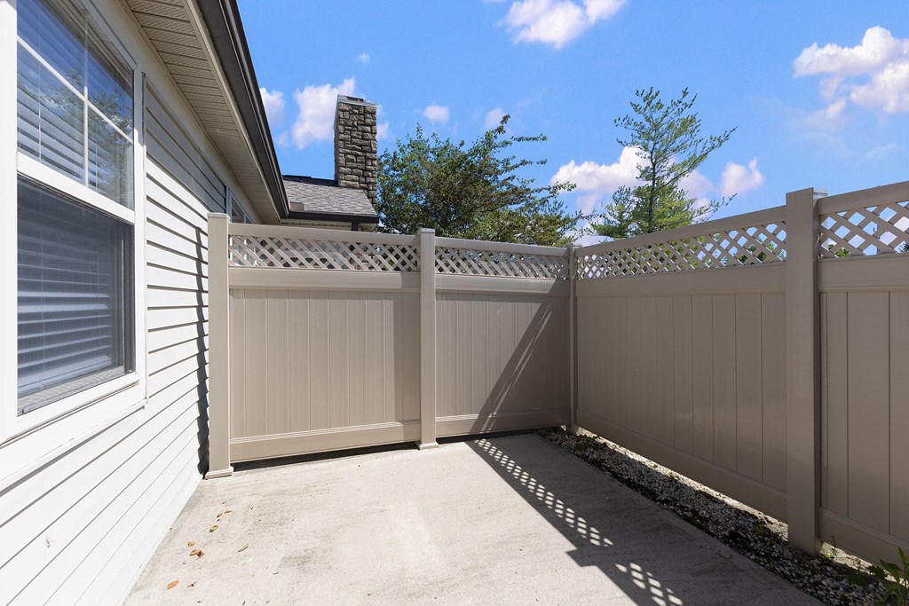 a white fence with a sidewalk in front of a house