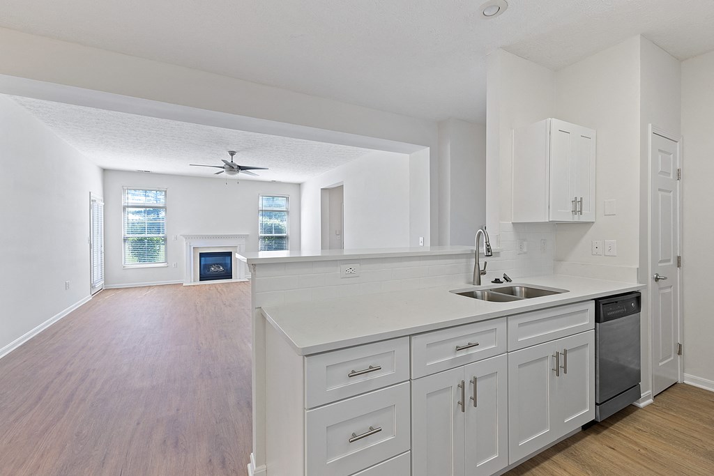 an empty kitchen with white cabinets and a sink
