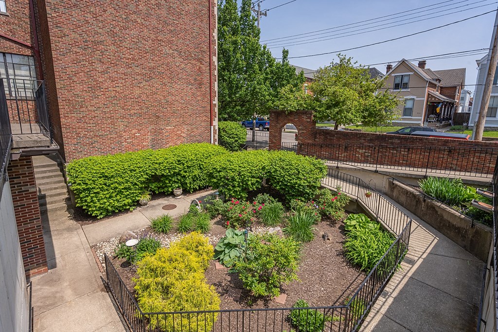 a garden in front of a brick building