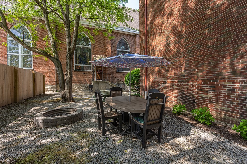 a patio with a table and chairs and a fire pit