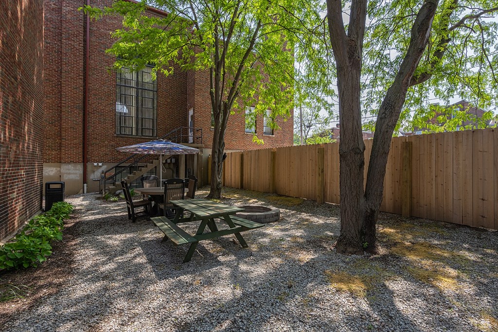 a patio with a picnic table and a tree