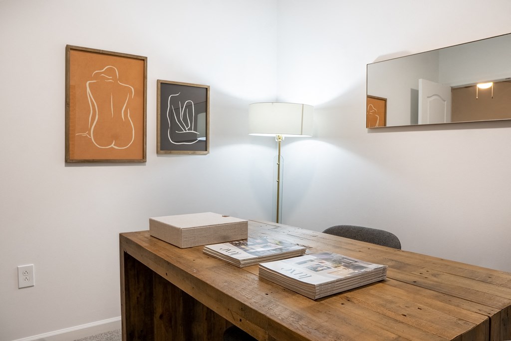a desk with books and a lamp in a room with paintings on the wall  at Waterstone Landing, Ohio, 43551