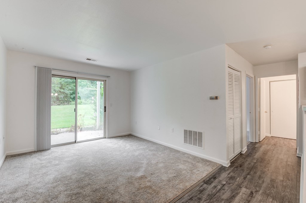 a living room with white walls and a sliding glass door