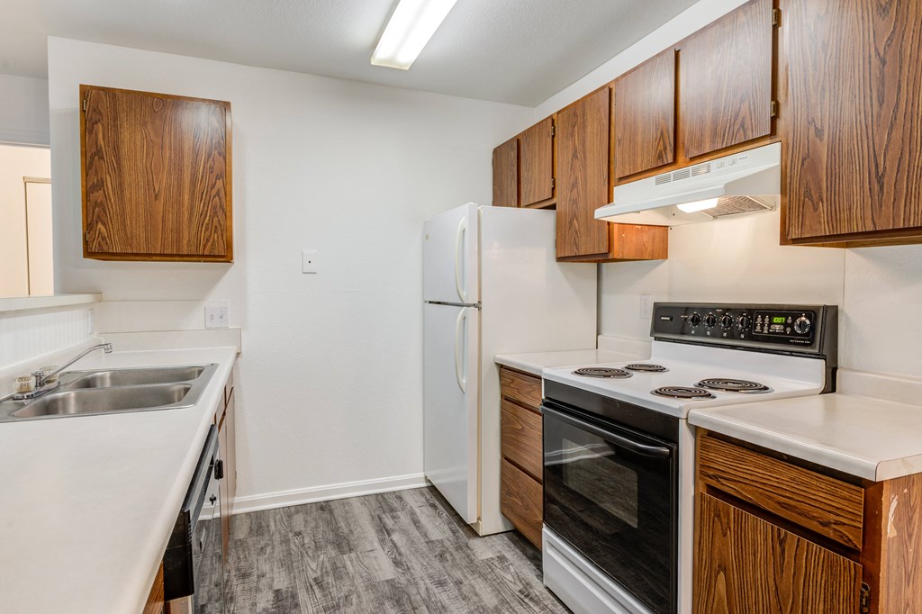 a kitchen with white appliances and wooden cabinets
