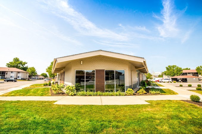 a building with glass doors and a lawn in front of it
