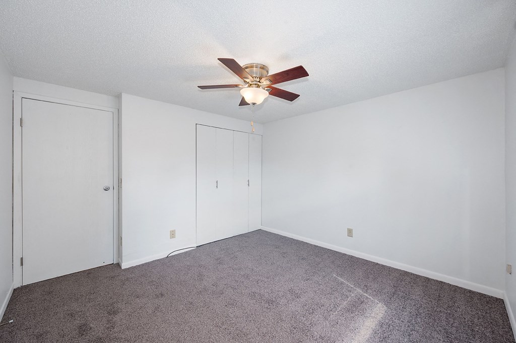 a bedroom with carpet and a ceiling fan