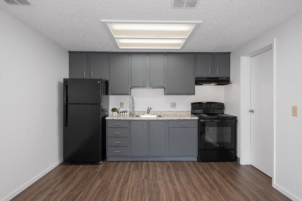 a kitchen with black appliances and a sink and refrigerator