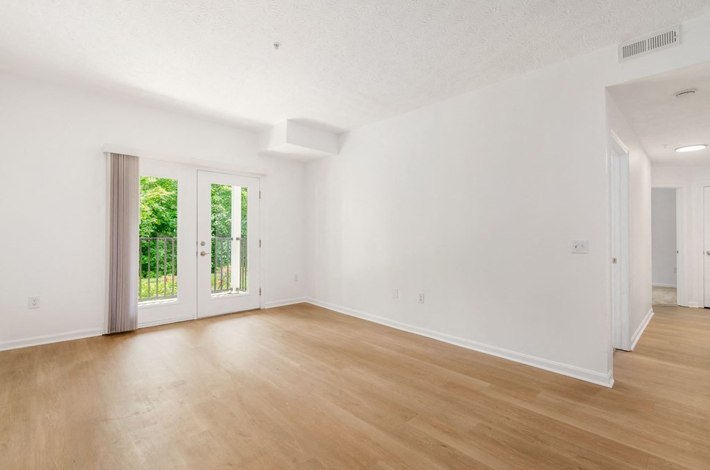 an empty living room with white walls and wood floors at Prescott Place, Columbus, OH