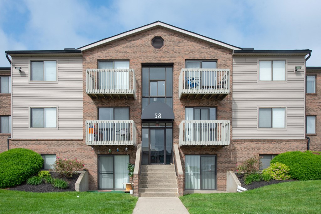 a brick apartment building with two balconies and a sidewalk at The Woodridge Collection, Fairfield