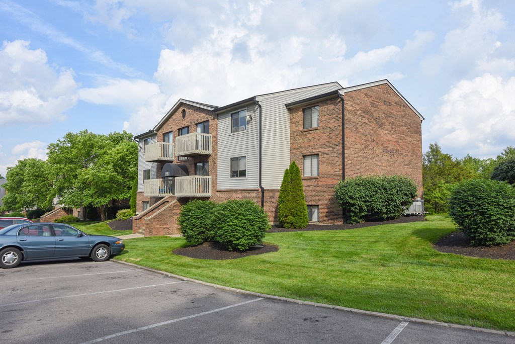 an apartment building with a parking lot and grass at The Woodridge Collection, Ohio, 45014