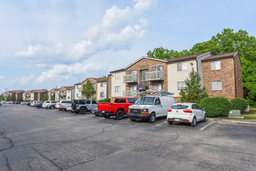 a parking lot filled with cars in front of apartment buildings at The Woodridge Collection, Fairfield
