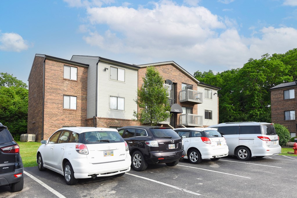 a group of cars parked in a parking lot in front of an apartment building at The Woodridge Collection, Fairfield, Ohio