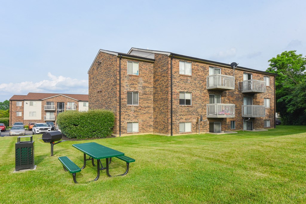 a green picnic table in front of an apartment building at The Woodridge Collection, Fairfield
