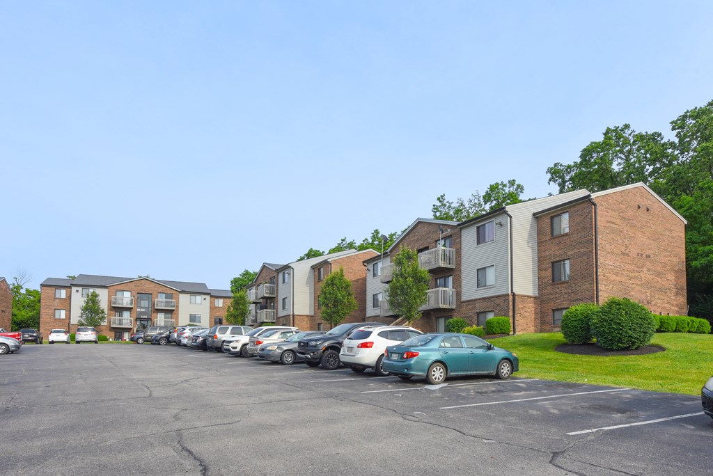 a parking lot with cars parked in front of apartment buildings at The Woodridge Collection, Fairfield, OH 45014