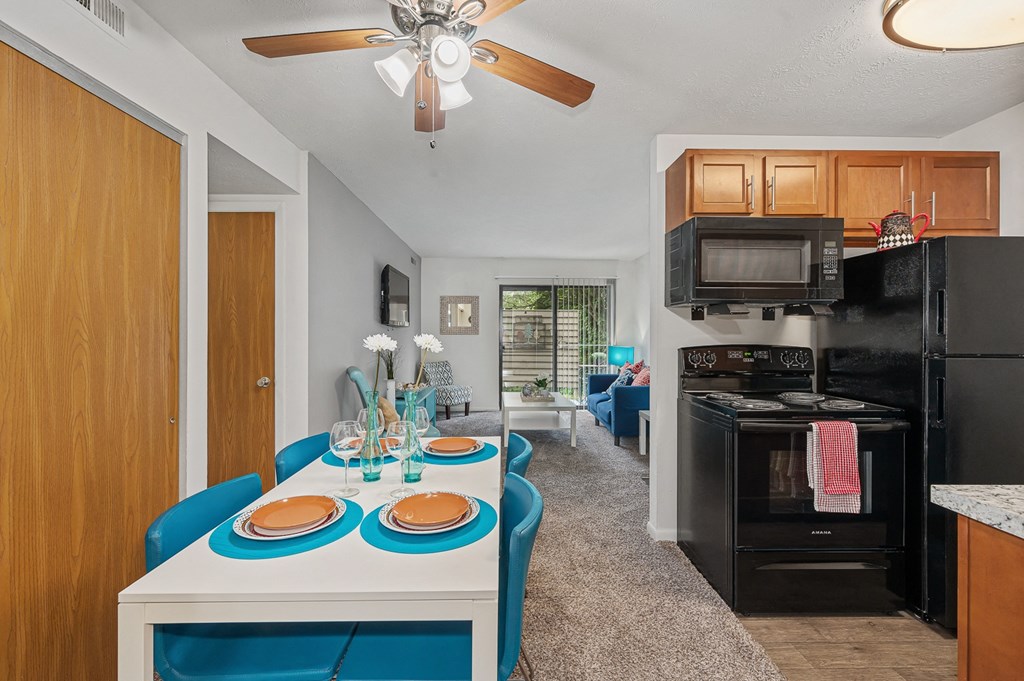 a kitchen and living room with a white table and blue chairs at The Woodridge Collection, Ohio, 45014