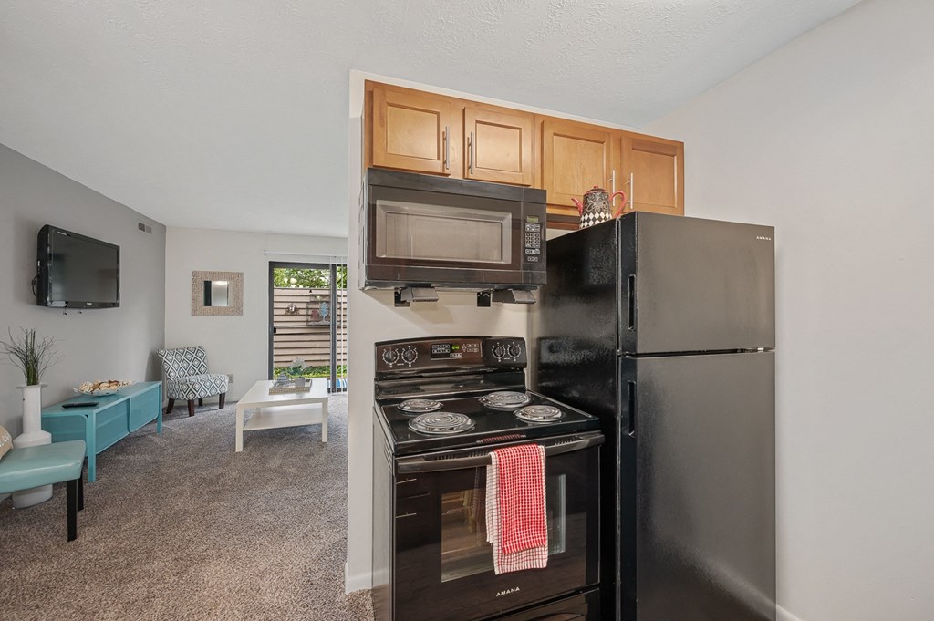 a kitchen with a stove microwave and refrigerator at The Woodridge Collection, Fairfield, OH