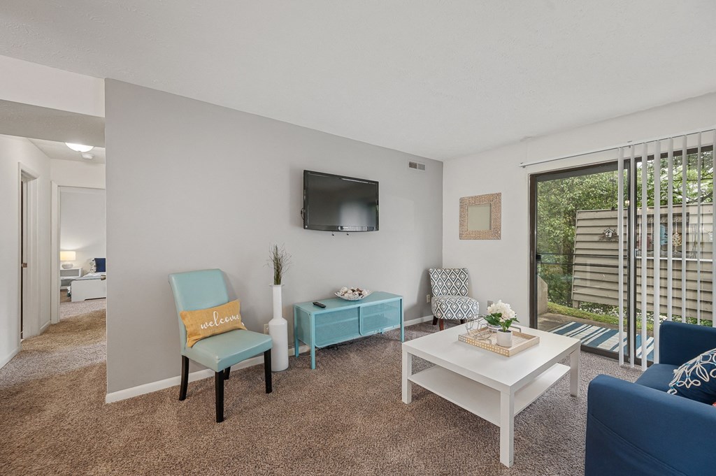 our apartments offer a living room with a couch coffee table and tv at The Woodridge Collection, Ohio