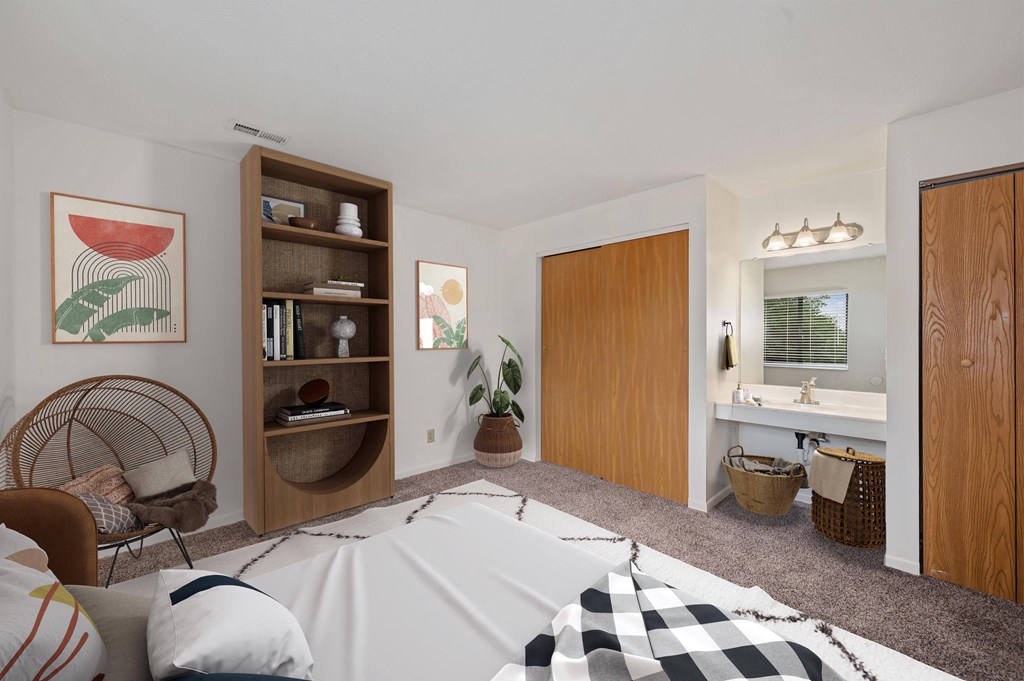 a bedroom with a bed and a bathroom with a sink and a mirror at The Woodridge Collection, Fairfield, OH