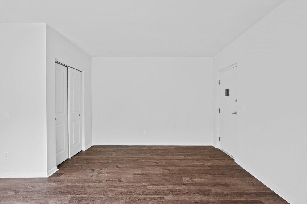 an empty room with white walls and wood floors