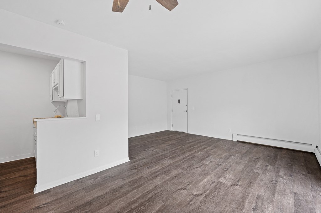 an empty living room with white walls and wood floors