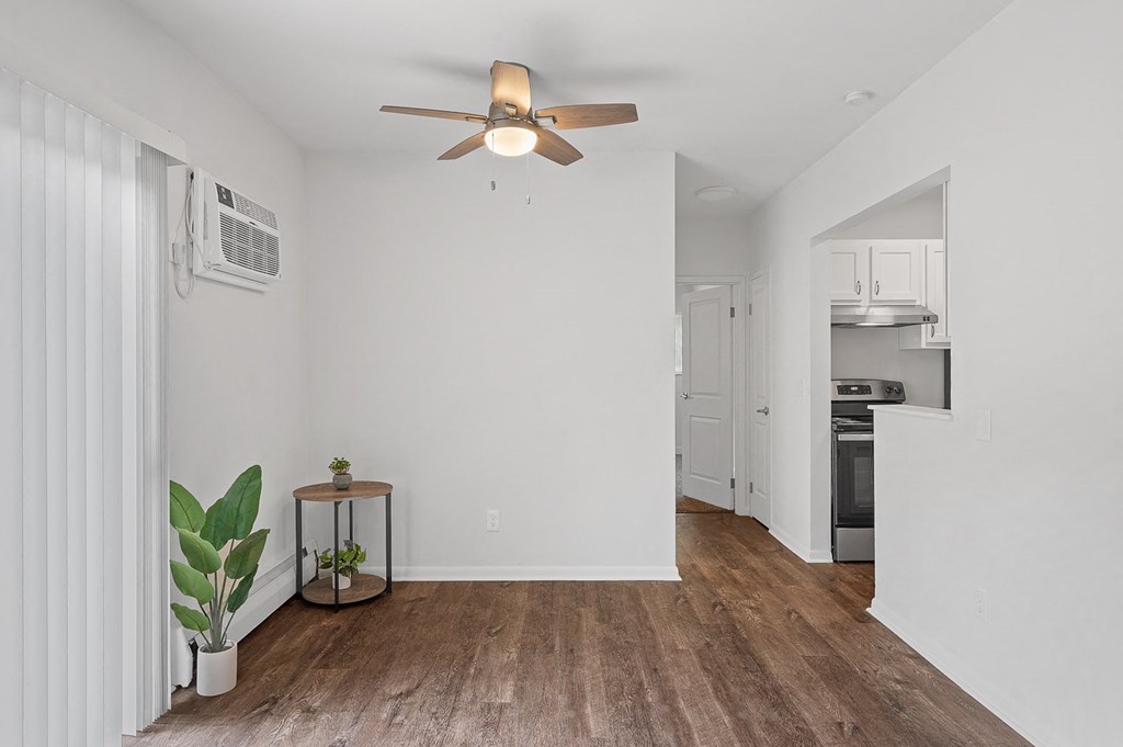 a living room with white walls and a ceiling fan