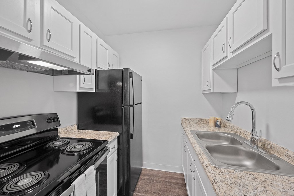 a kitchen with white cabinets and a black stove and refrigerator