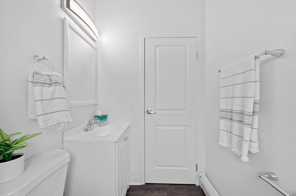 a white bathroom with a sink and a door