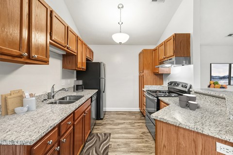 A kitchen with wooden cabinets and granite countertops.