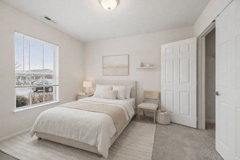 Cozy bedroom with neutral tones and carpet at North Central Village Apartments, Columbus, 43211