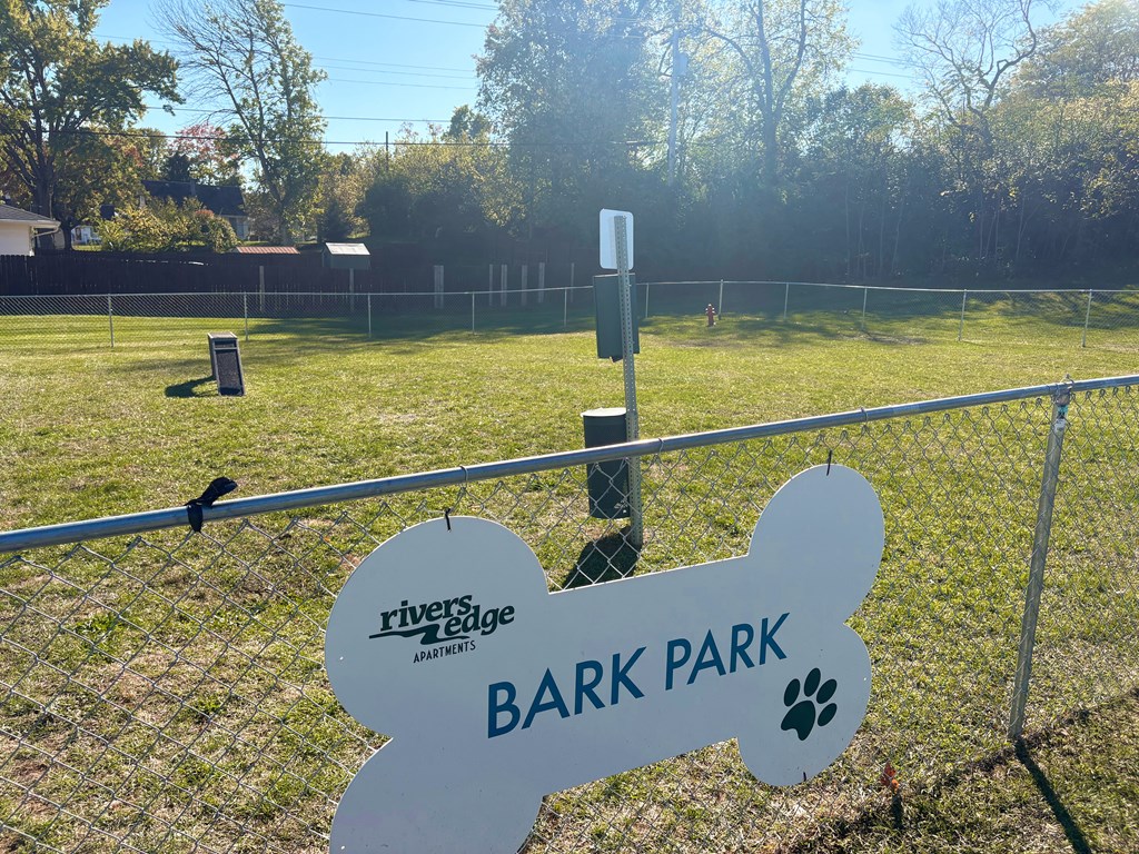 A sign for Bark Park is displayed in front of a fence.